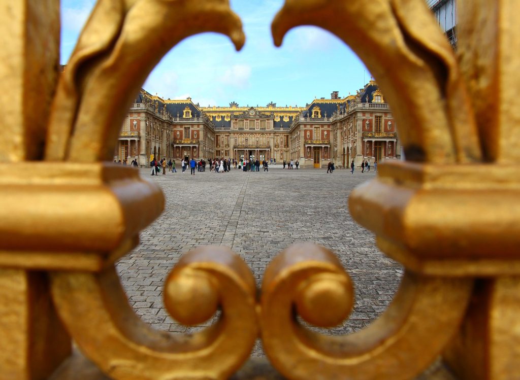 Portail doré du Palais de Versailles avec touristes