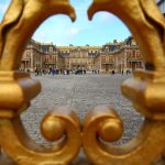 Portail doré du Palais de Versailles avec touristes