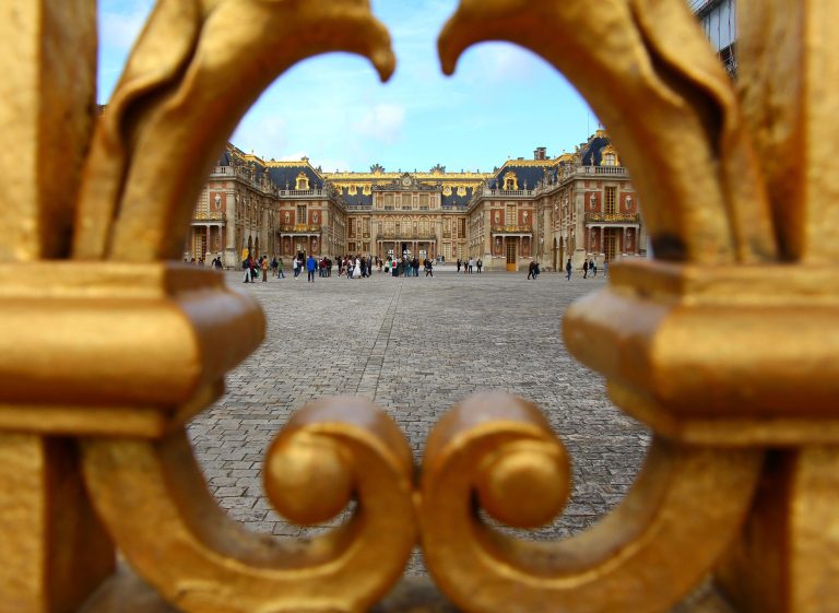 Portail doré du Palais de Versailles avec touristes