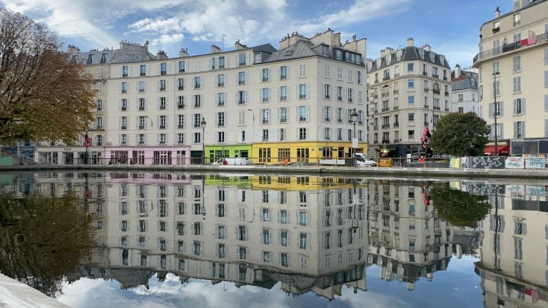 Bâtiments parisiens colorés reflétés dans le canal