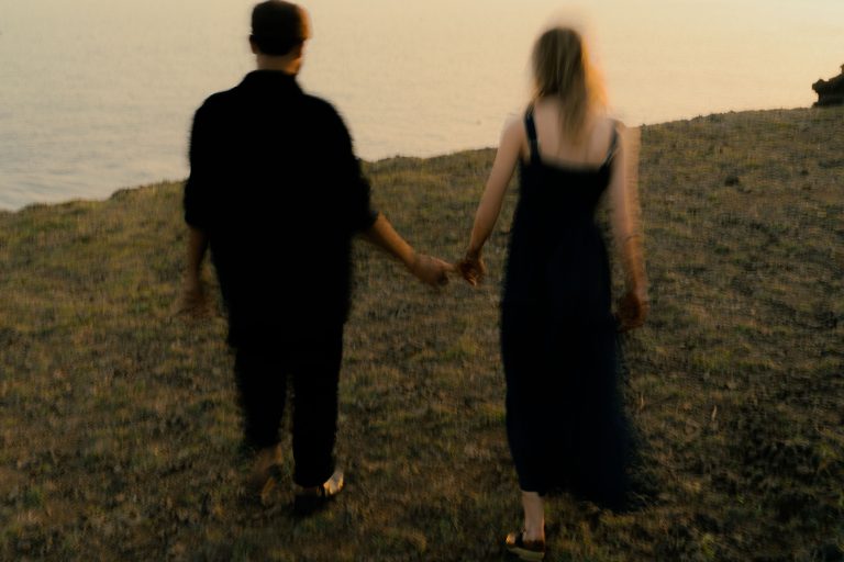 Couple se tenant la main au coucher de soleil