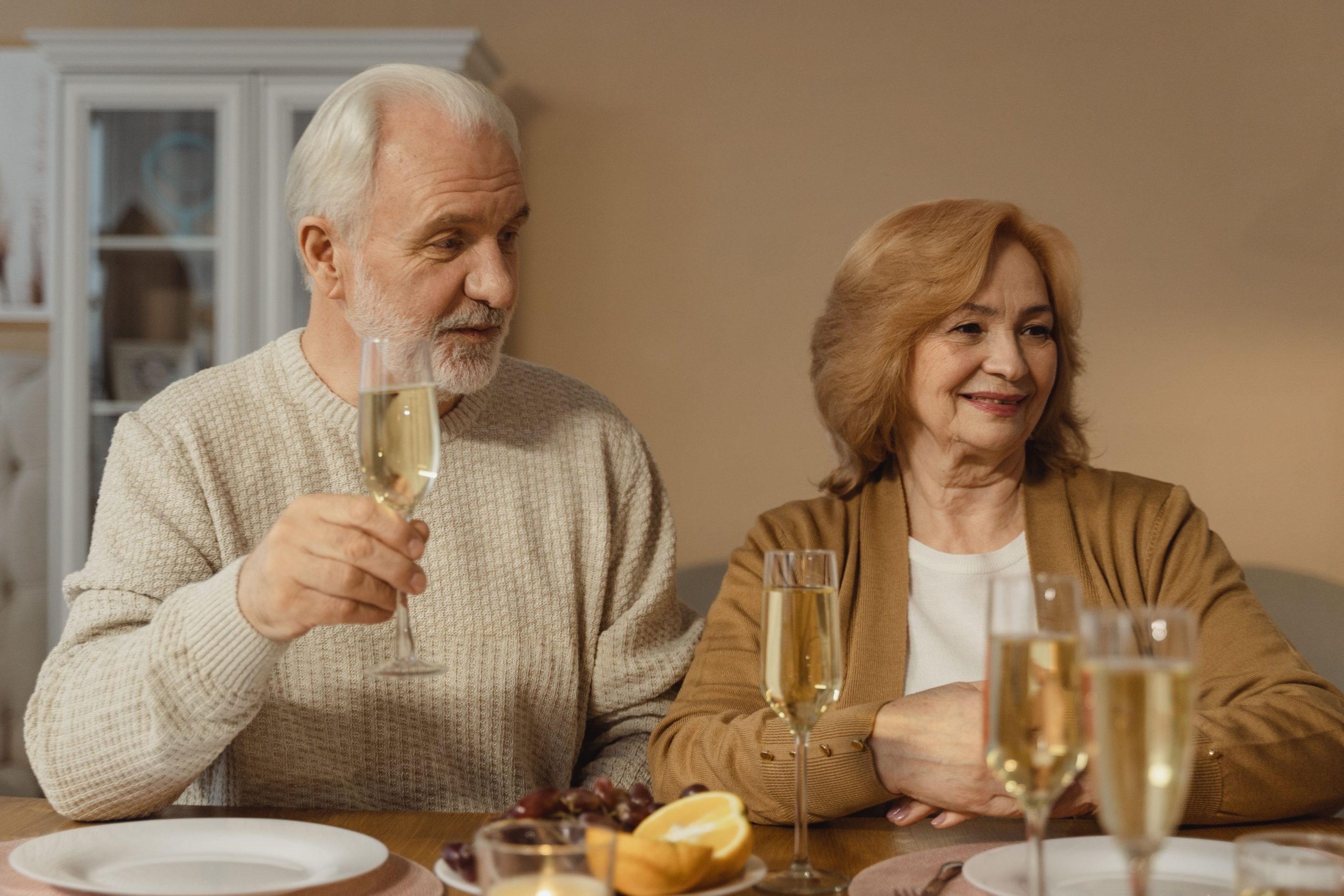 Couple senior portant un toast champagne joyeusement