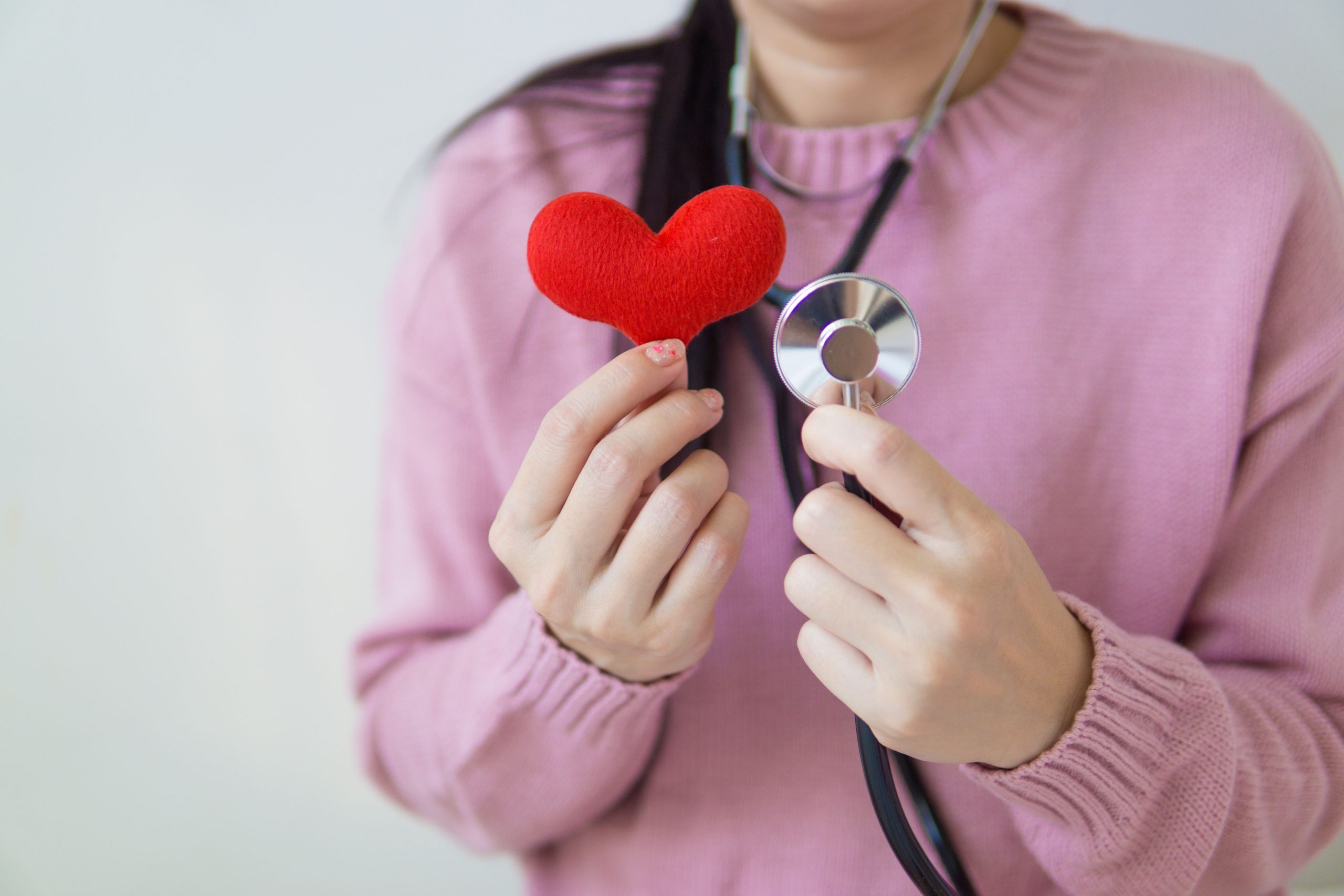 Professionnelle santé avec stéthoscope tenant cœur rouge