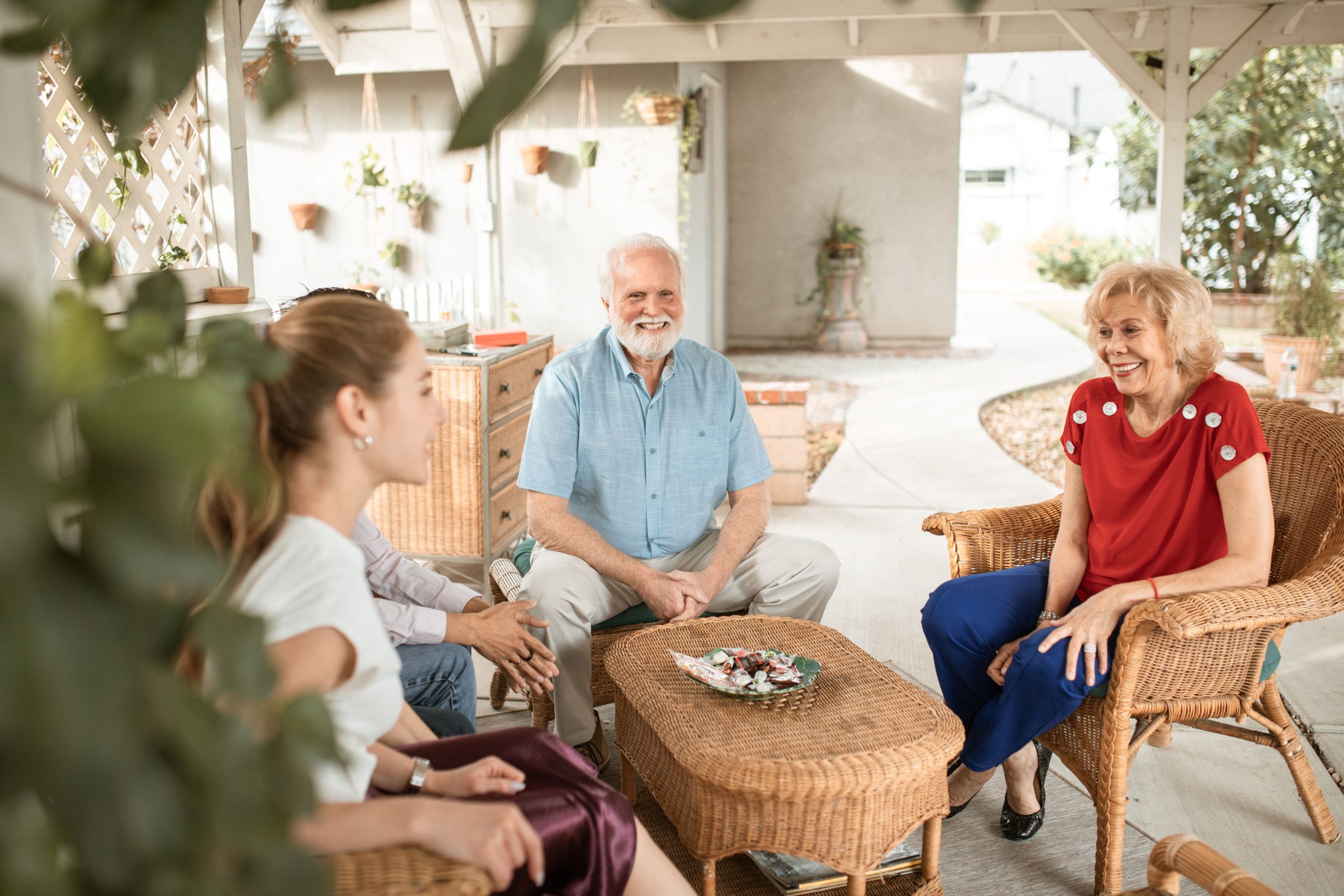 Famille discutant sereinement sur terrasse confortable.