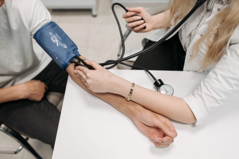 Médecin mesure tension artérielle patient consultation