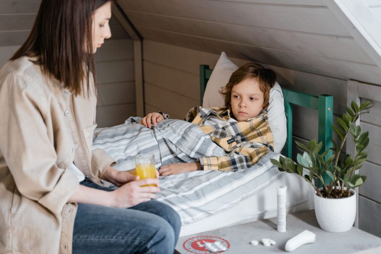 Mère donnant du jus d'orange à son enfant malade