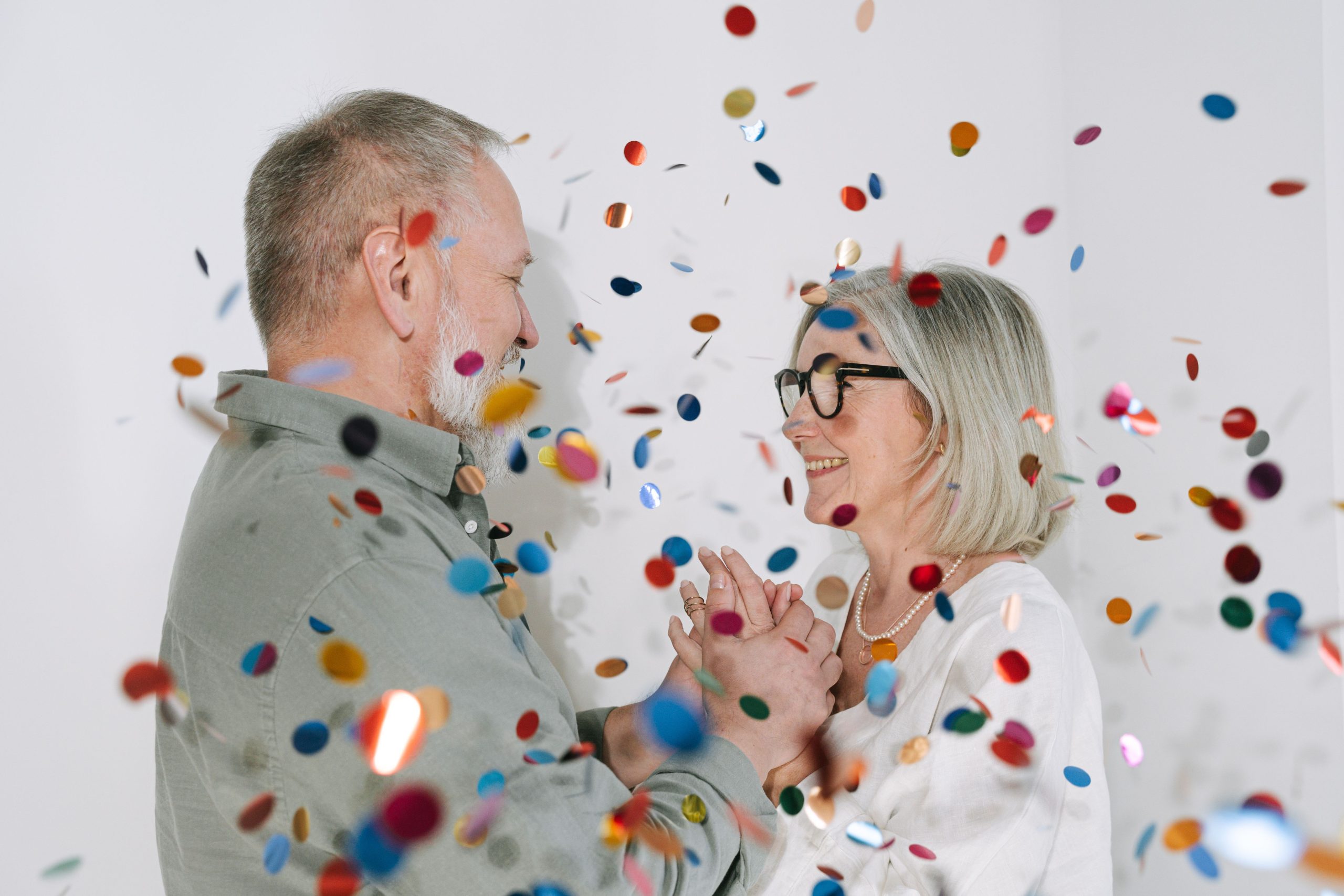 Couple heureux souriant confettis colorés intérieur
