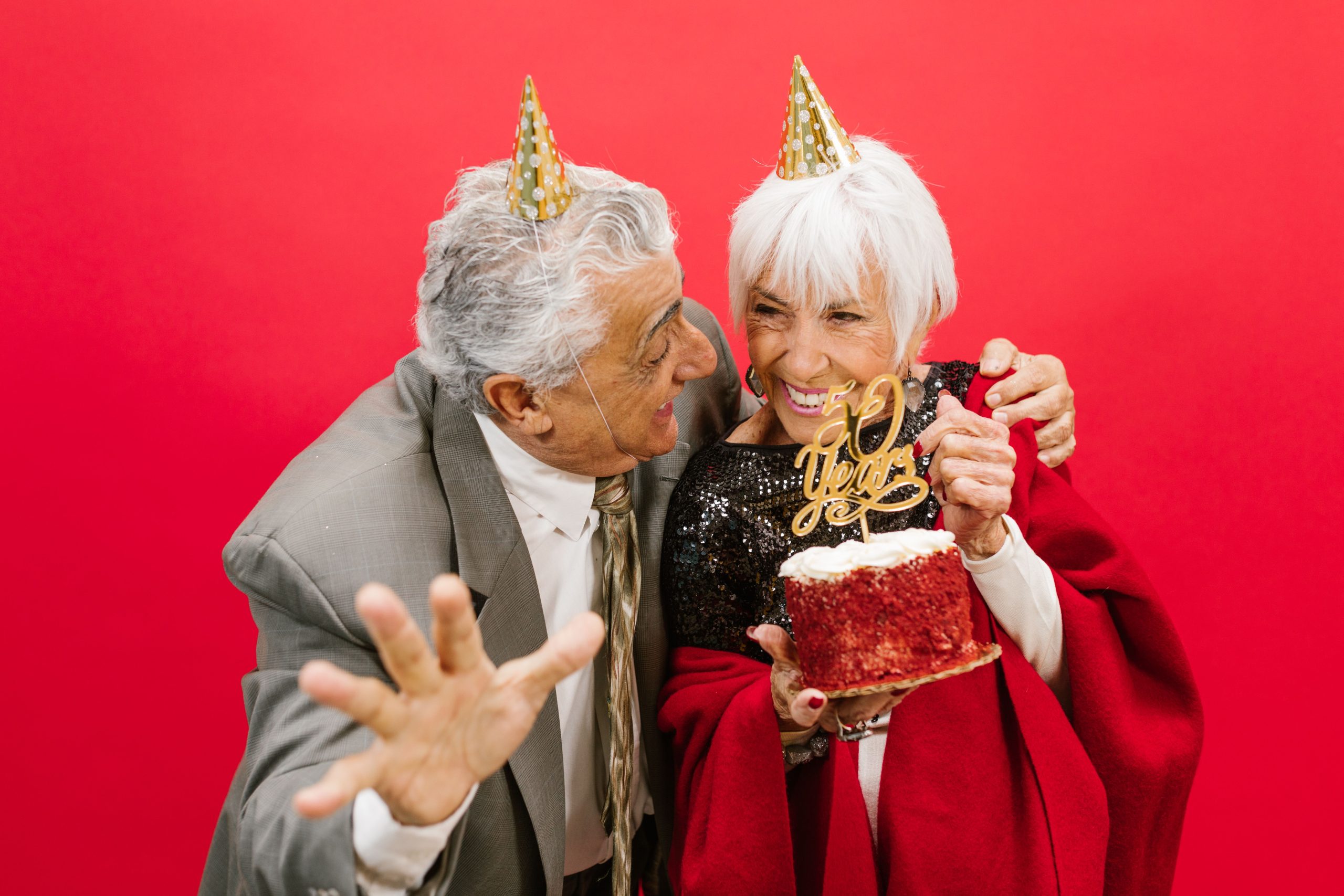 Couple senior en chapeaux de fête célébrant anniversaire de mariage