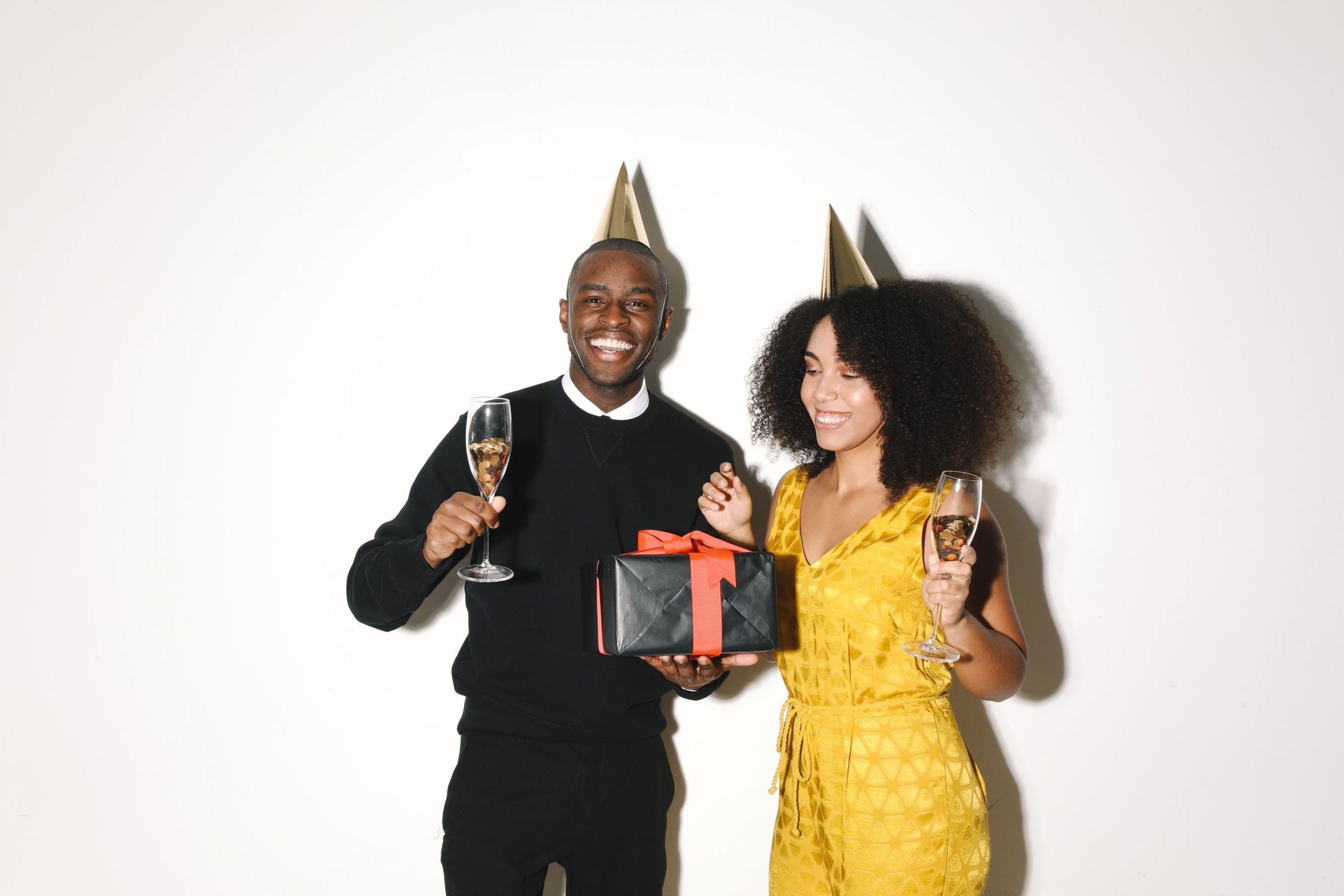 Couple célébrant avec champagne et cadeau intérieur.