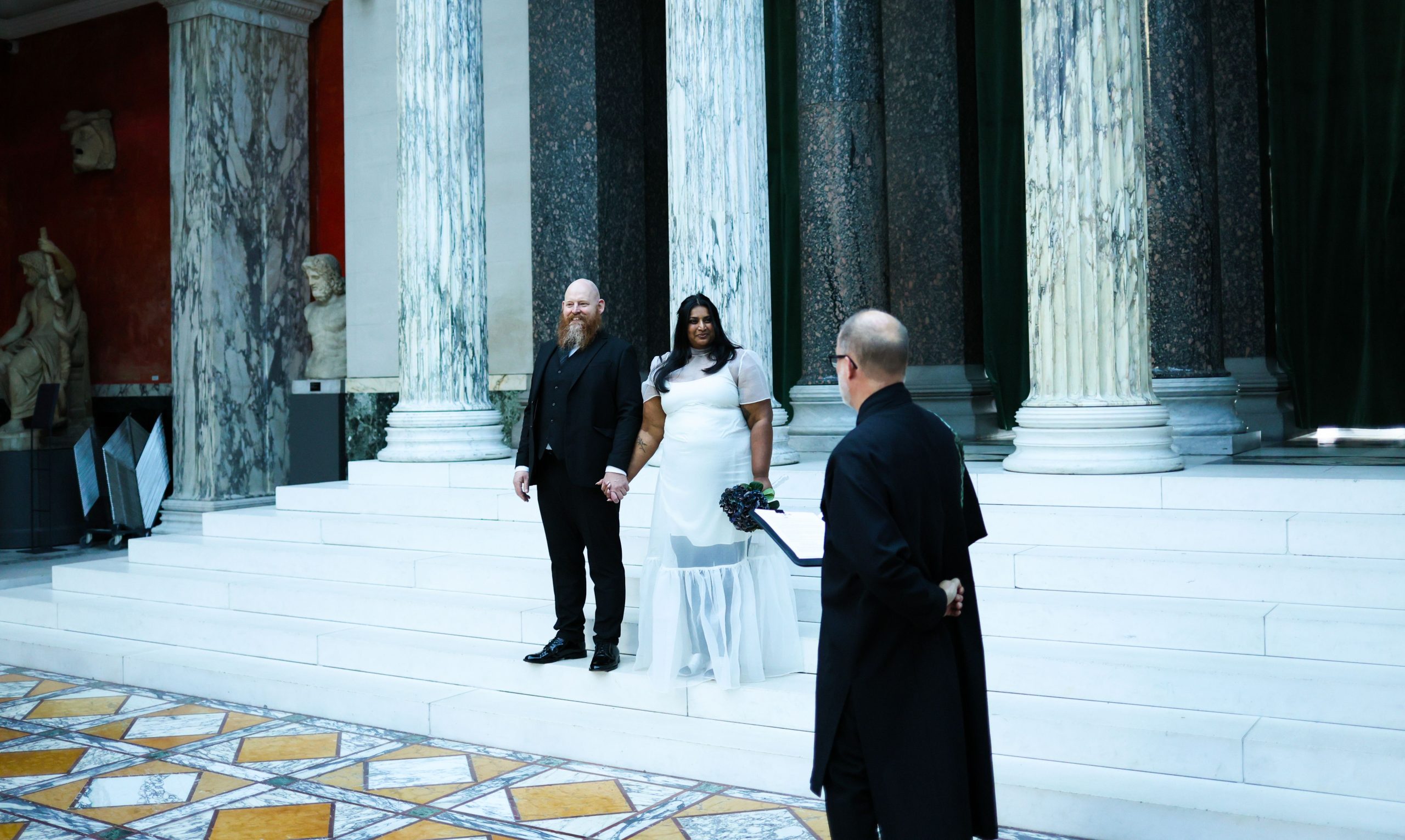 Couple de mariés dans une grande salle à colonnes