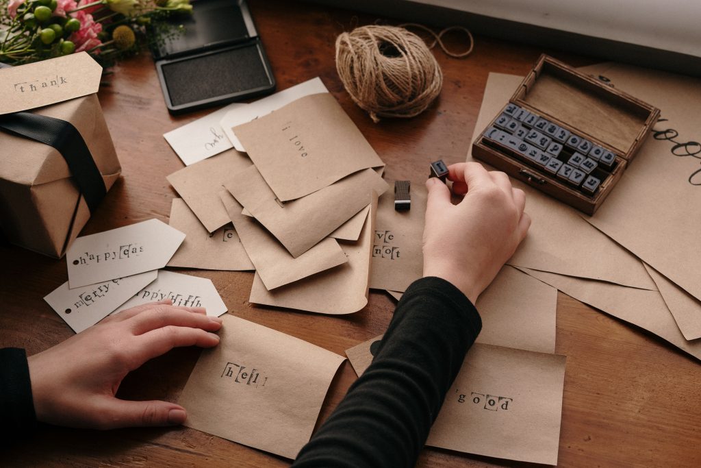 Personne qui colle un timbre sur une enveloppe