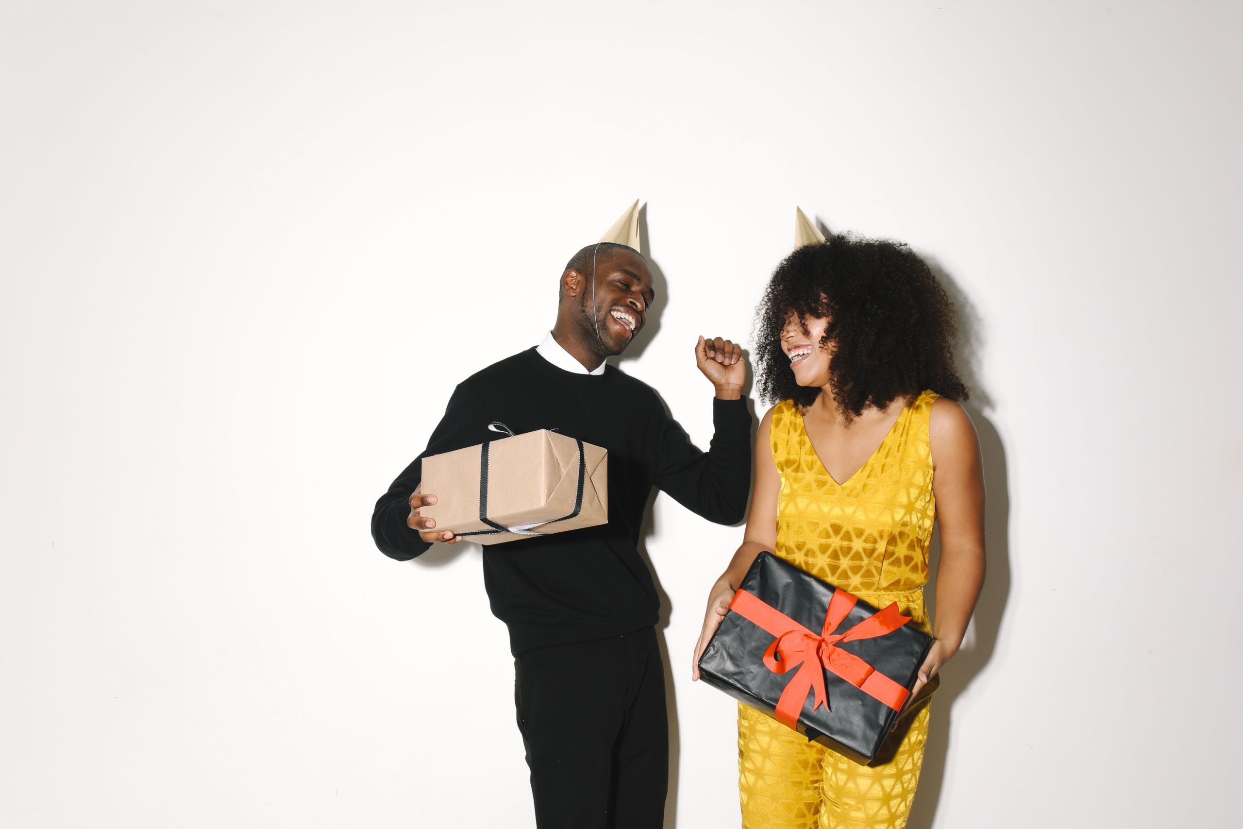 Couple joyeux avec chapeaux de fête et cadeaux.