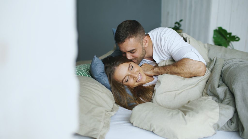 Couple romantique se blottissant au lit tendrement
