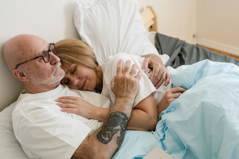 Couple senior s'embrassant au lit avec tendresse
