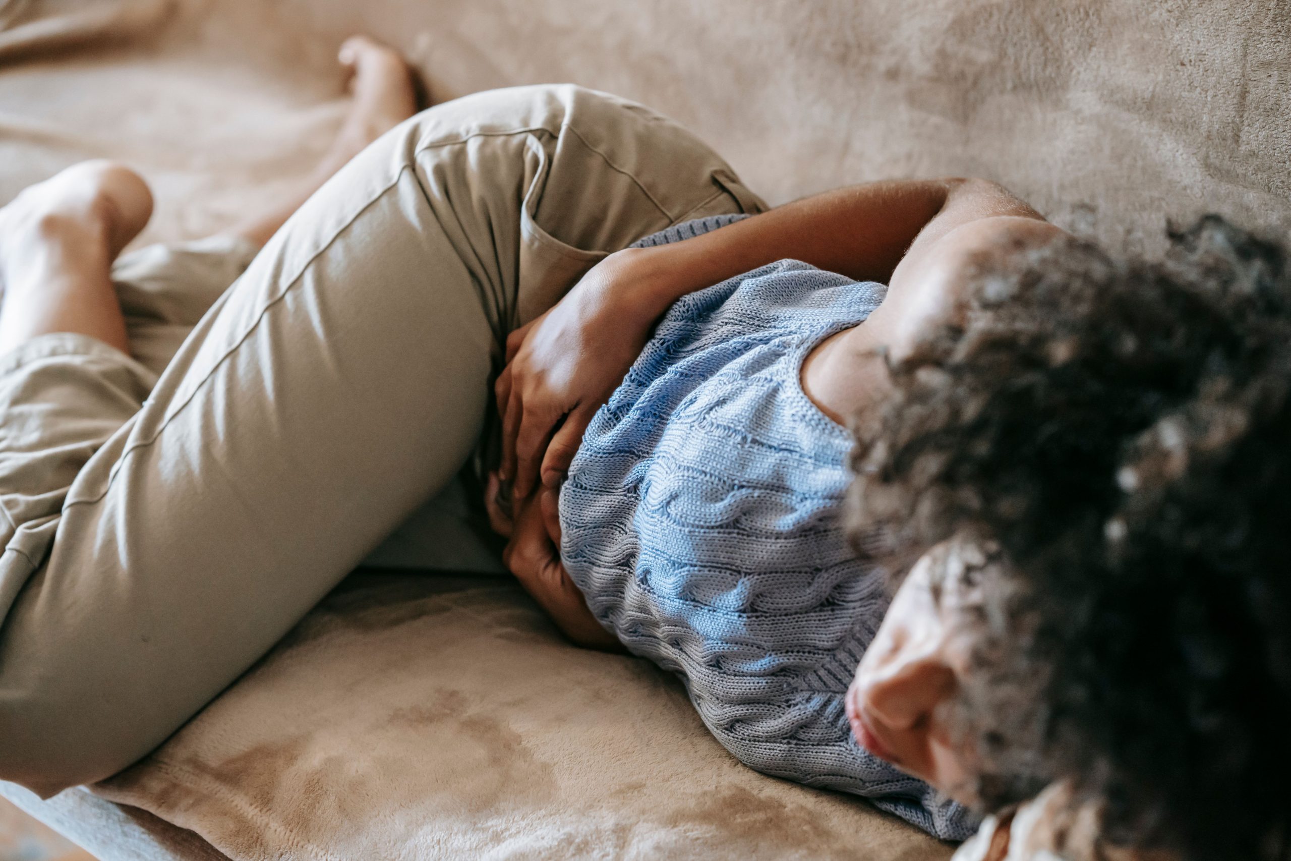 Femme allongée touchant son ventre douloureux