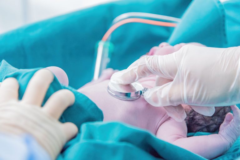 Médecin examinant un nouveau-né au stéthoscope