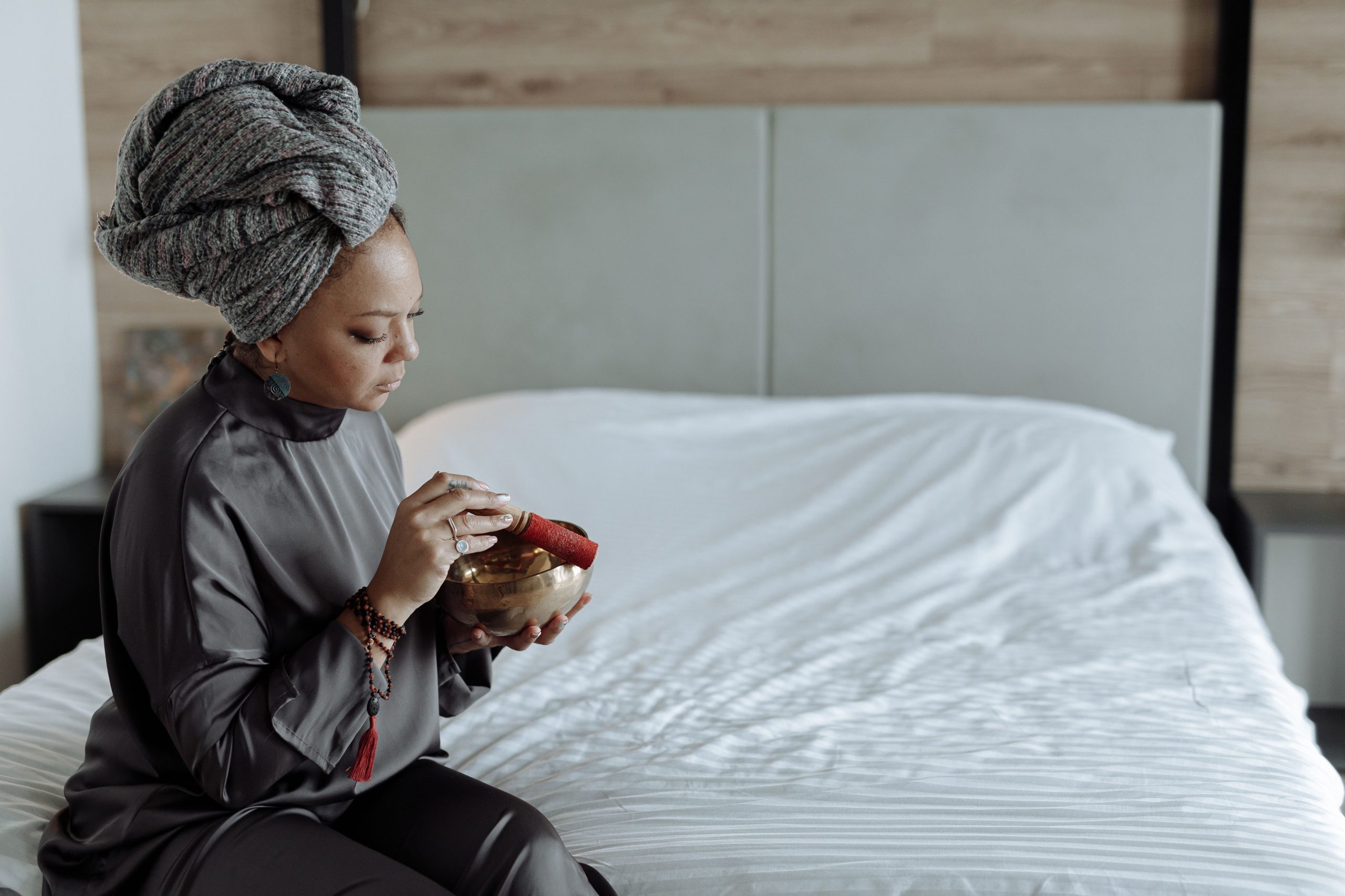 Femme méditant sur lit avec bol chantant tibétain