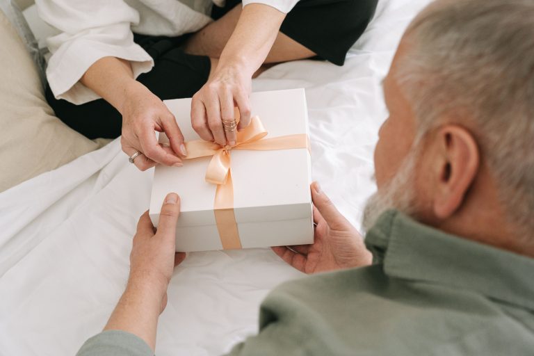 Couple partageant une boîte cadeau ruban orange