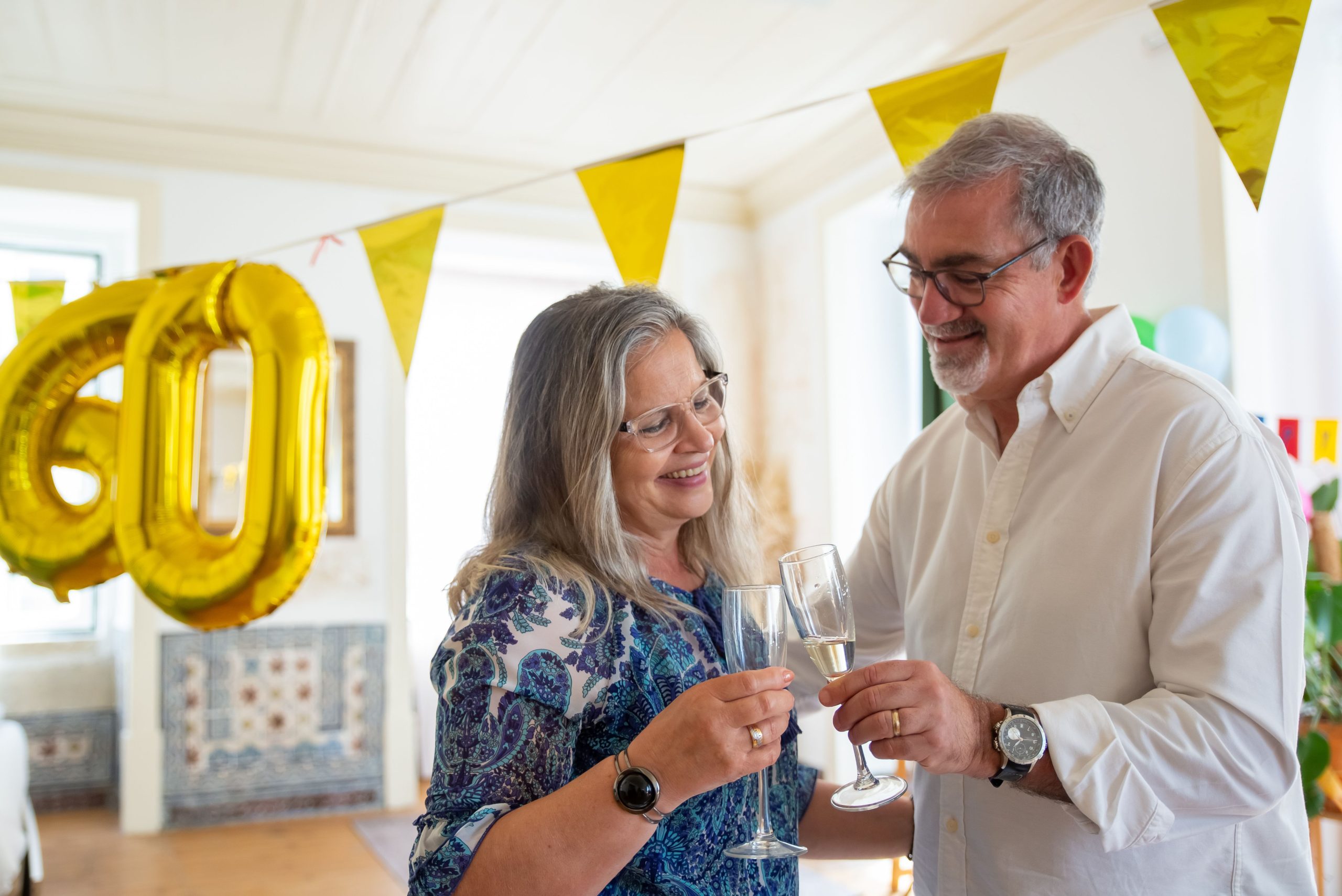 Couple âgé trinquant aux noces de diamant avec champagne