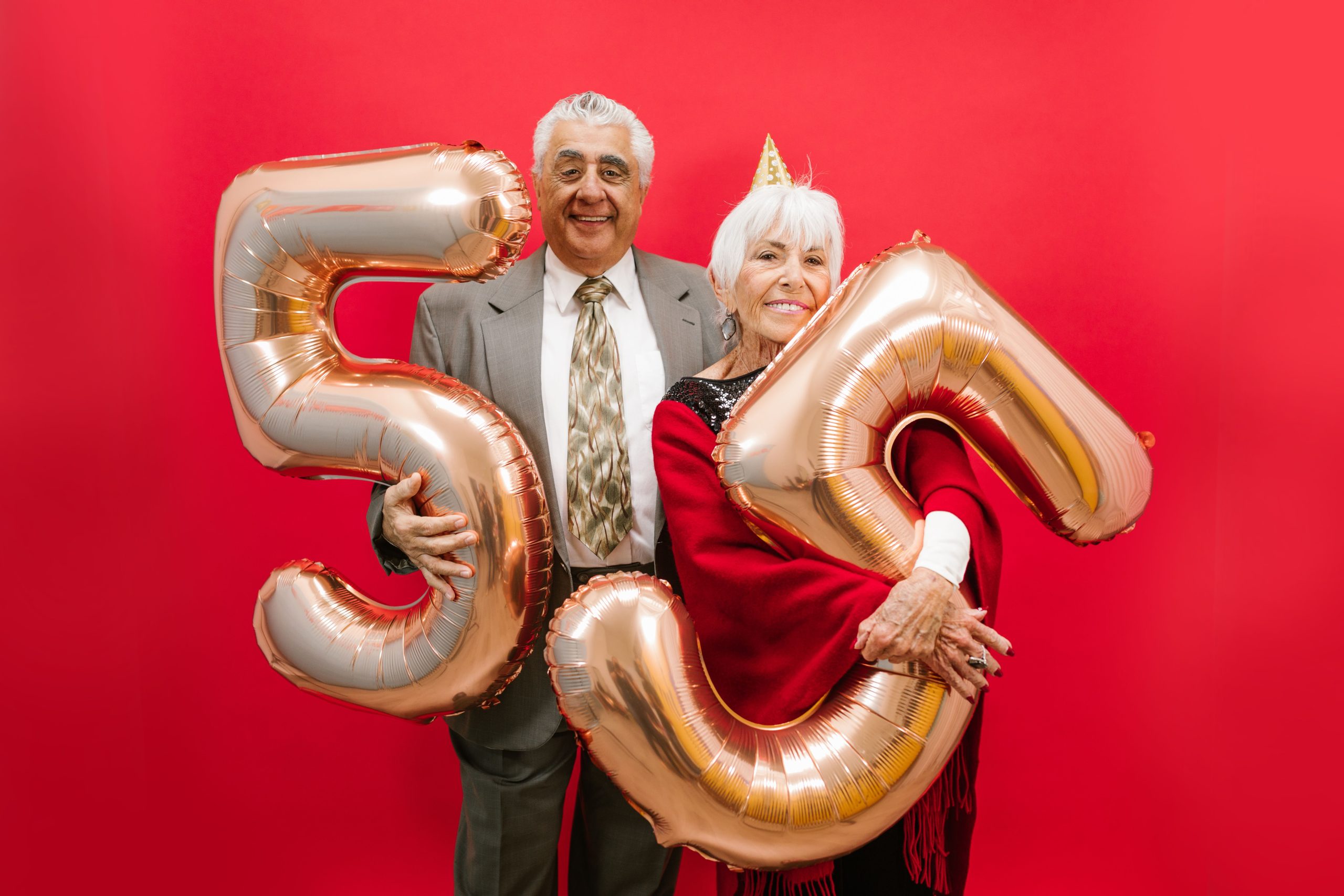 Couple senior élégant fêtant noces diamant ballons dorés