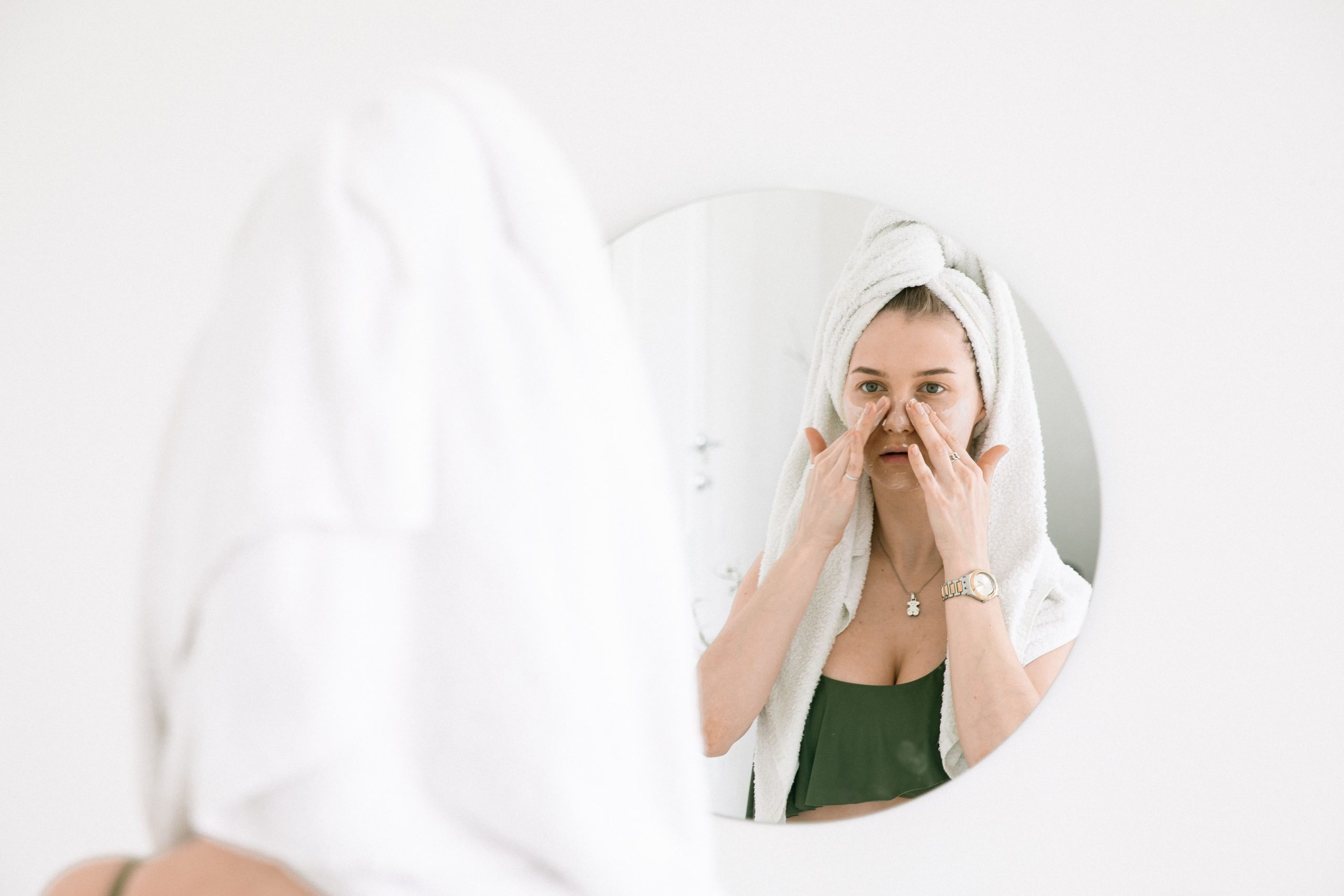 Femme serviette routine soin devant miroir salle bain